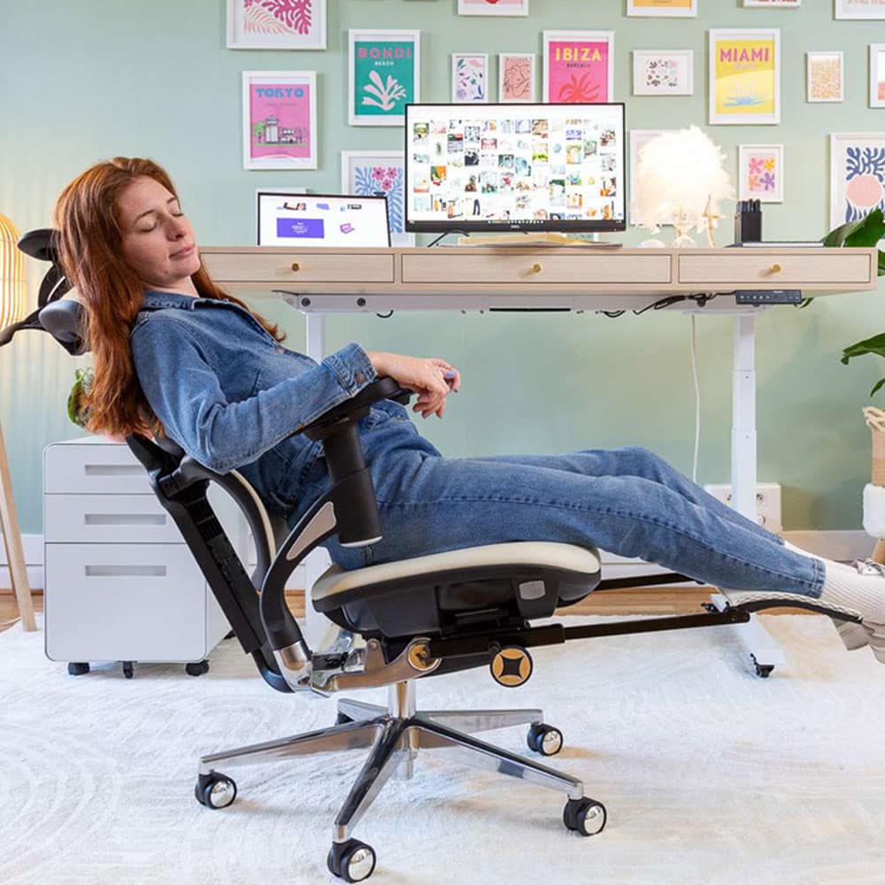 Utilisatrice détendue sur fauteuil ergonomique Kqueo devant un bureau assis-debout