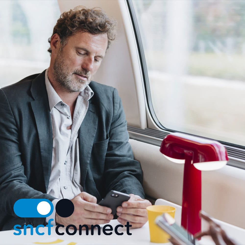 Utilisateur consultant l'application SNCF Connect dans un train
